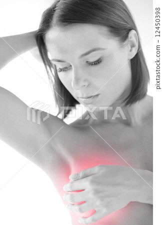 woman checking breast for signs of cancer woman checking breast for signs of cancer 12450398