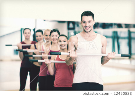 group of smiling people working out with barbells