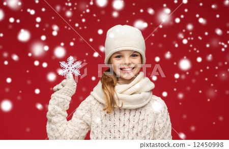 smiling girl in winter clothes with big snowflake 12450998
