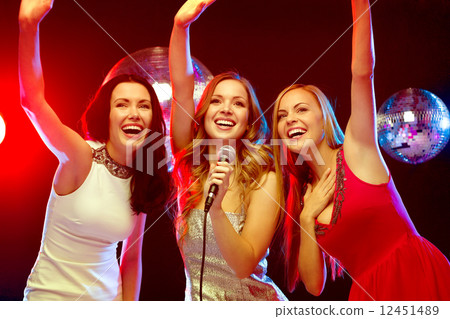 three smiling women dancing and singing karaoke three smiling women dancing and singing karaoke 12451489