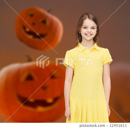 smiling girl in dress over pumpkins background smiling girl in dress over pumpkins background 12451611