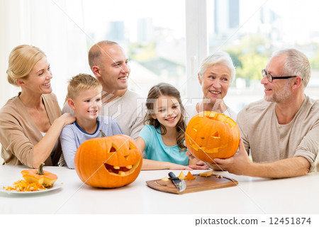 happy family sitting with pumpkins at home 12451874