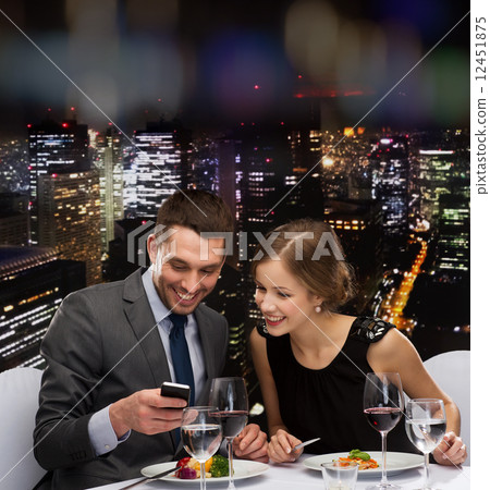 smiling couple eating main course at restaurant 12451875