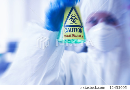 Scientist in protective suit holding beaker 12453095