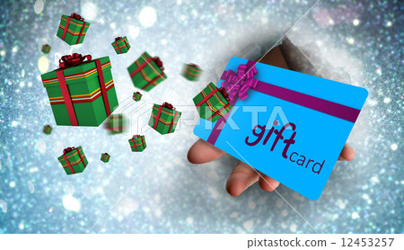 Composite image of hand bursting through paper 12453257