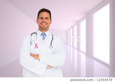 Composite image of handsome doctor with arms crossed 12454579