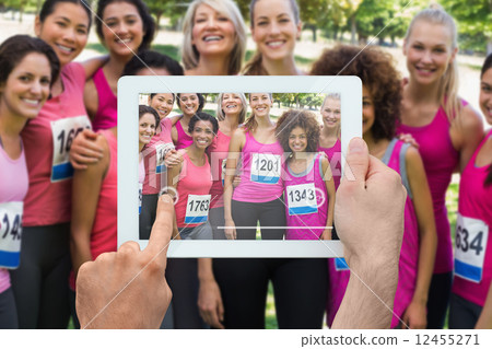 Composite image of hand holding tablet pc 12455271