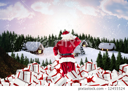 Composite image of santa standing on pile of gifts Composite image of santa standing on pile of gifts 12455524