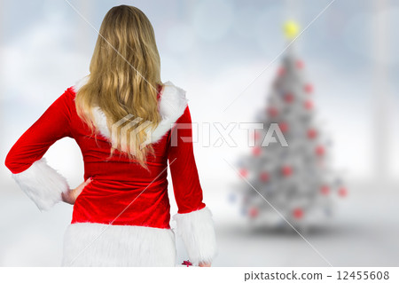 Composite image of pretty girl in santa outfit holding gift 12455608