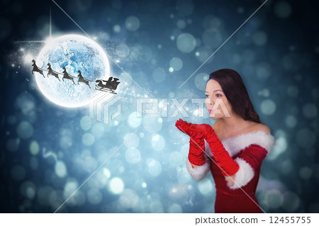 Composite image of pretty girl in santa outfit blowing 12455755