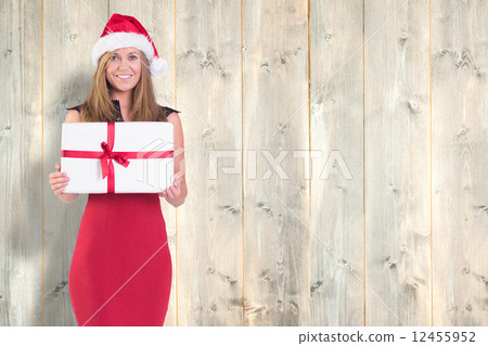 Composite image of festive blonde showing a gift Composite image of festive blonde showing a gift 12455952