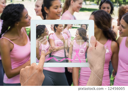 Composite image of hand holding tablet pc 12456005