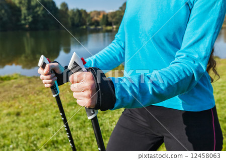 Closeup of woman's hand with nordic walking poles 12458063