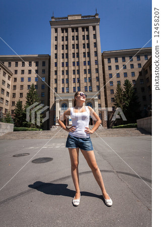 slim woman standing on street against high building slim woman standing on street against high building 12458207