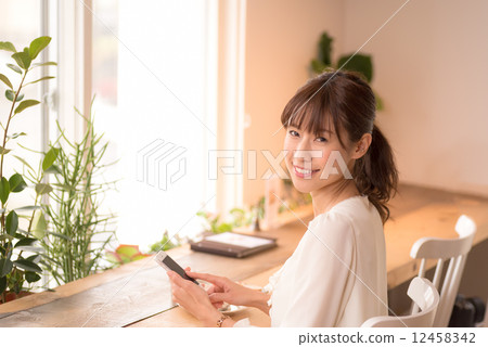 A woman using a smartphone at a cafe 12458342