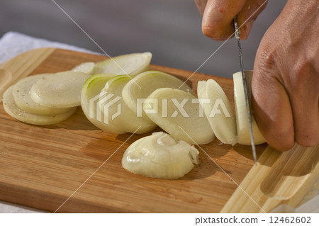 cutting raw onions on a wooden board cutting raw onions on a wooden board 12462602