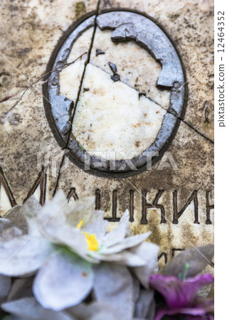 Damaged portrait of the buried person on the old gravestone Damaged portrait of the buried person on the old gravestone 12464352