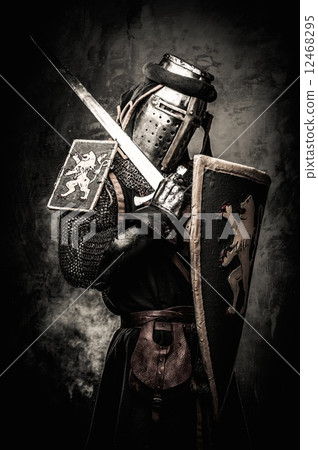 Medieval knight with a sword against stone wall Medieval knight with a sword against stone wall 12468295