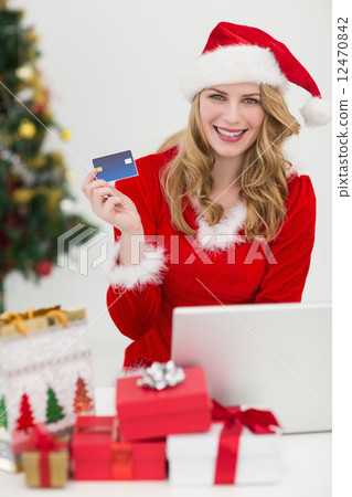 Blonde shopping online with laptop while smiling at camera 12470842
