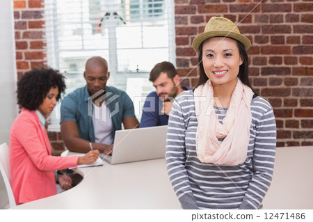 Woman with colleagues behind in office Woman with colleagues behind in office 12471486