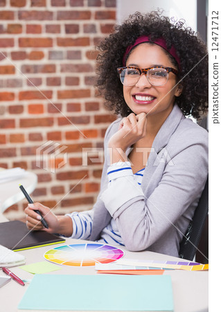 Smiling female photo editor using digitizer in office 12471712