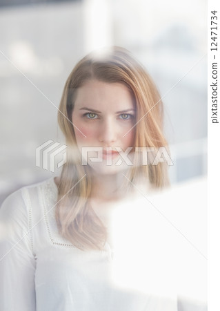 Thoughtful blonde woman looking at camera Thoughtful blonde woman looking at camera 12471734
