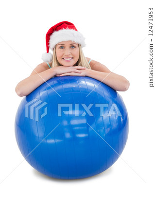 Festive fit blonde leaning on exercise ball 12471953