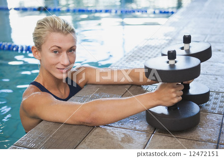 Female swimmer with foam dumbbells in swimming pool Female swimmer with foam dumbbells in swimming pool 12472151