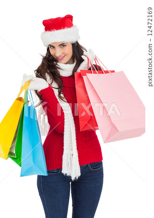 Smiling brunette in winter wear holding shopping bags Smiling brunette in winter wear holding shopping bags 12472169