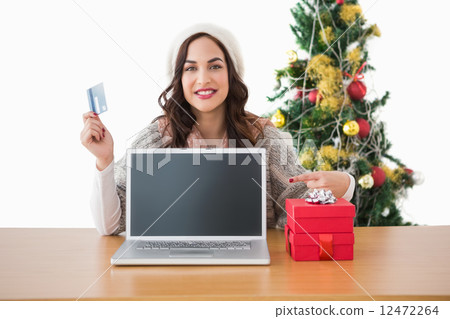 Brunette holding credit card and showing her laptop 12472264