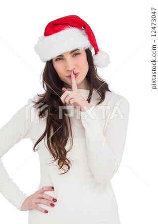 Festive brunette in santa hat keeping a secret Festive brunette in santa hat keeping a secret 12473047
