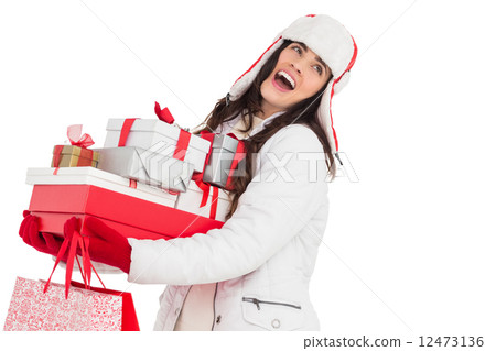 Brunette in winter clothes holding many gifts and shopping bags 12473136