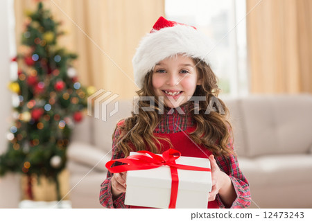 Festive little girl opening a gift 12473243