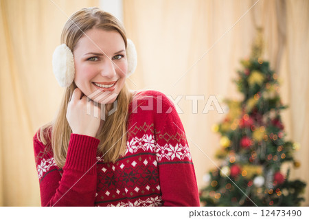 Portrait of a pretty smiling blonde wearing earmuffs 12473490