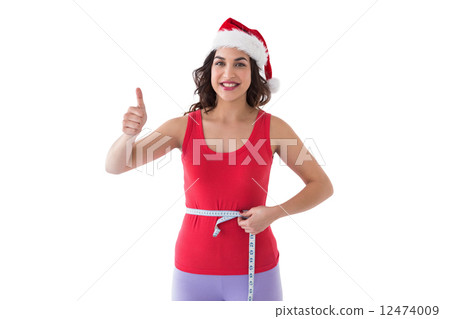 Festive fit brunette measuring her waist 12474009