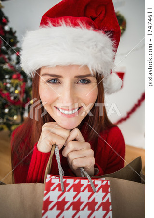 Festive redhead holding christmas gifts 12474611