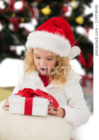 Festive little girl looking at gift Festive little girl looking at gift 12474646