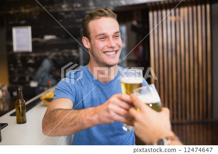 Young man toasting with pint of beer Young man toasting with pint of beer 12474647