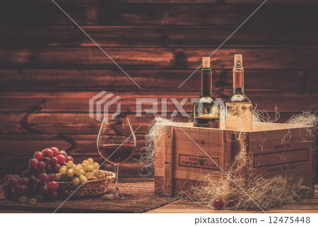 Bottles of red and white wine, glass and grape on a wooden interior Bottles of red and white wine, glass and grape on a wooden interior 12475448