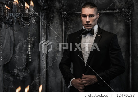 Young man wearing tuxedo in classical interior 12476158