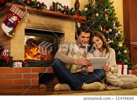 Couple near fireplace in Christmas decorated house interior 12476688