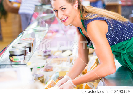 Saleswoman working at counter in groceries shop Saleswoman working at counter in groceries shop 12490399