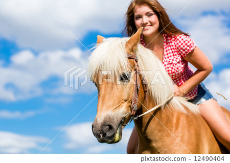 Woman riding on horse in summer meadow Woman riding on horse in summer meadow 12490404