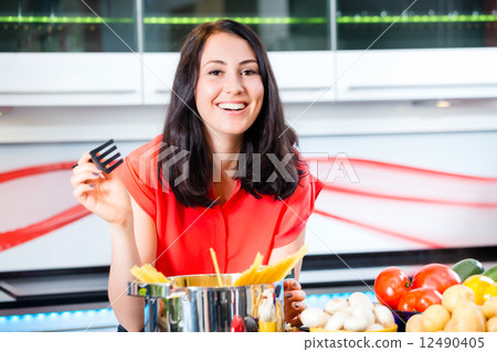 Woman cooking pasta in domestic kitchen Woman cooking pasta in domestic kitchen 12490405