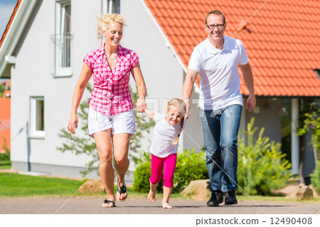 Family taking walk in front of home Family taking walk in front of home 12490408