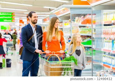 Family with shopping cart in supermarket store Family with shopping cart in supermarket store 12490412