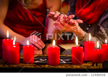 Soothsayer during session doing palmistry 12490439