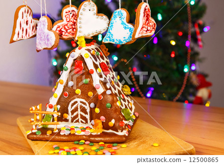 Gingerbread house with Christmas tree and lights on background. Gingerbread house with Christmas tree and lights on background. 12500865