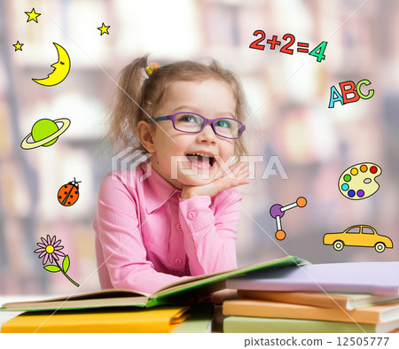 Funny smart kid in glasses reading book 12505777