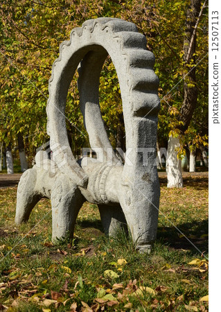 Stone statue featuring a wether with big horns- in the park of Astana, Kazakhstan 12507113